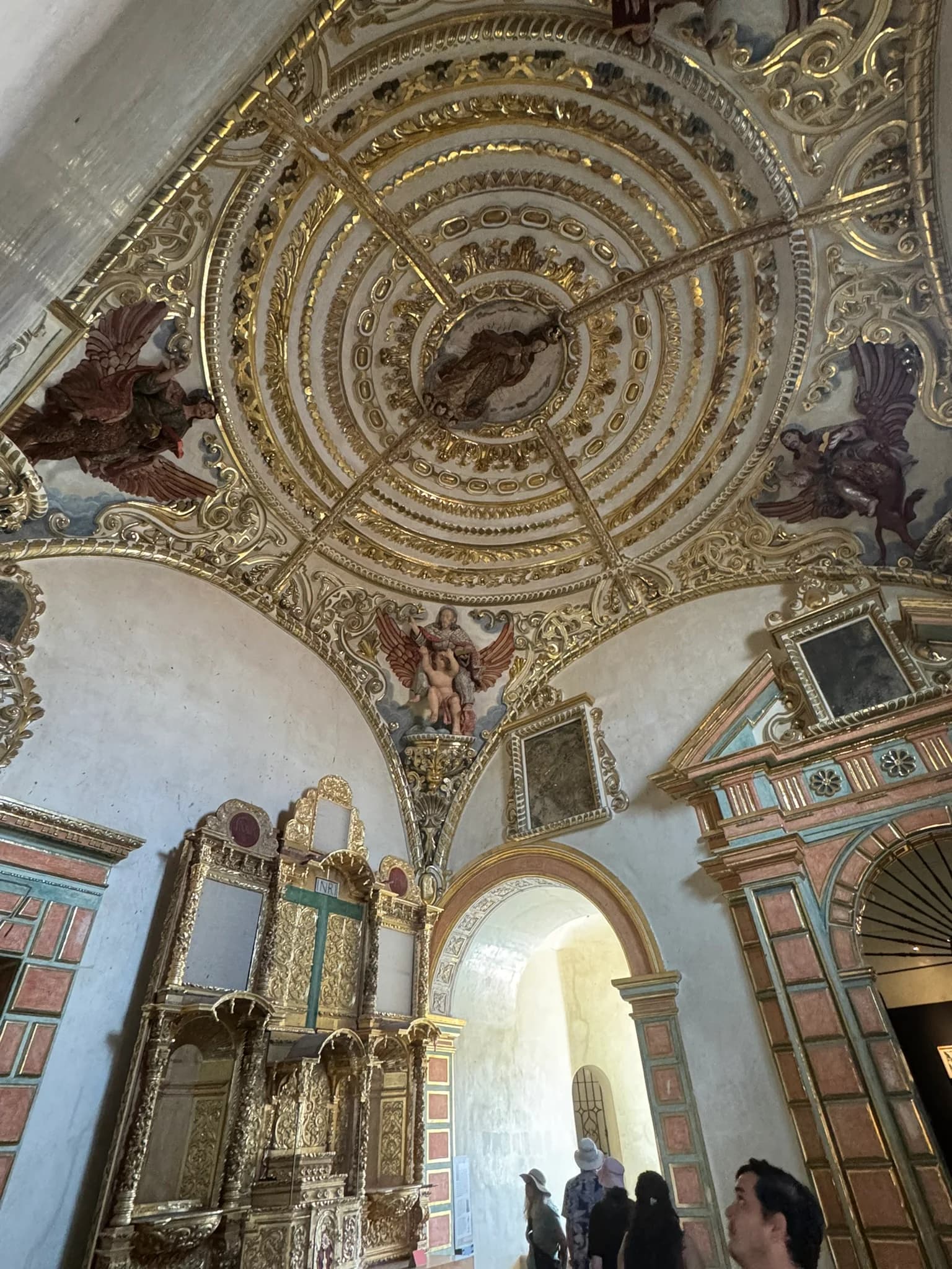 Gilded domed ceiling with carved angels above a gold retablo, Templo de Santo Domingo de Guzmán, Oaxaca