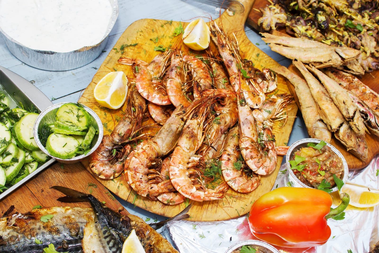 Grilled shrimp on a wooden board with vegetables