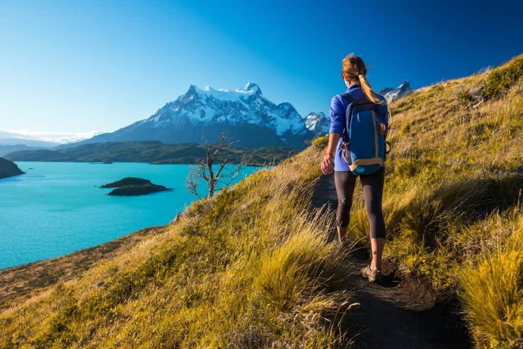 Woman hiker walks on the trail in the torres del paine national park. Chile