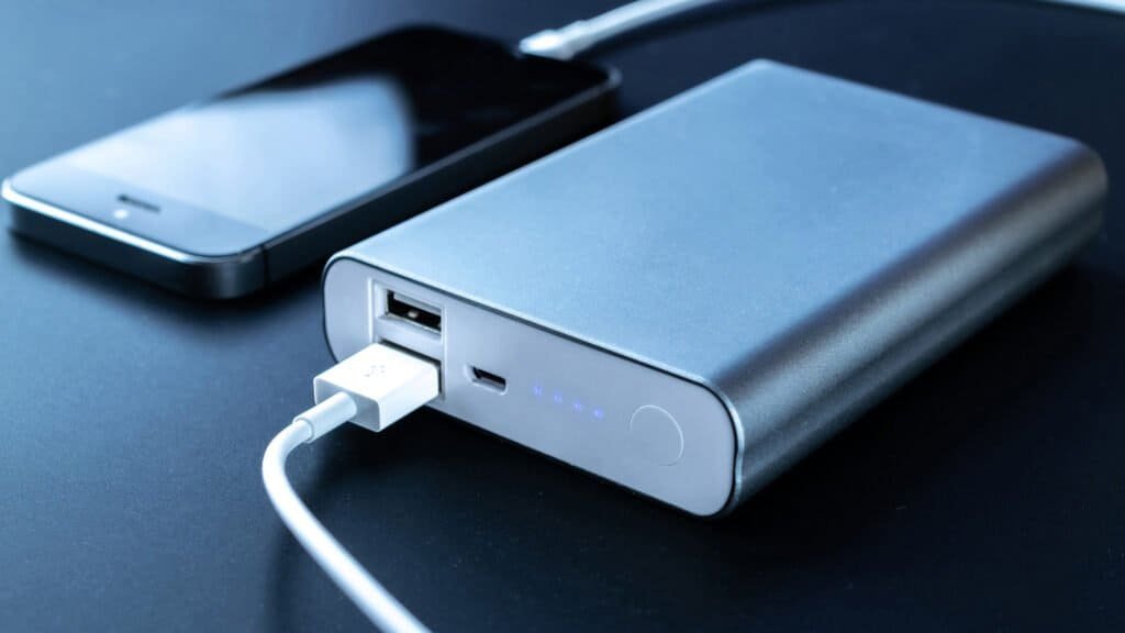 Charging phone. Portable powerbank with white usb cable for charger mobile phone or smartphone battery. Electronic devices concept