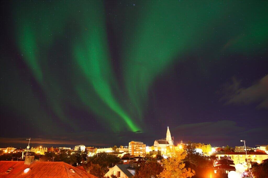 Aurora borealis, northern lights over the city of reykjavik, iceland