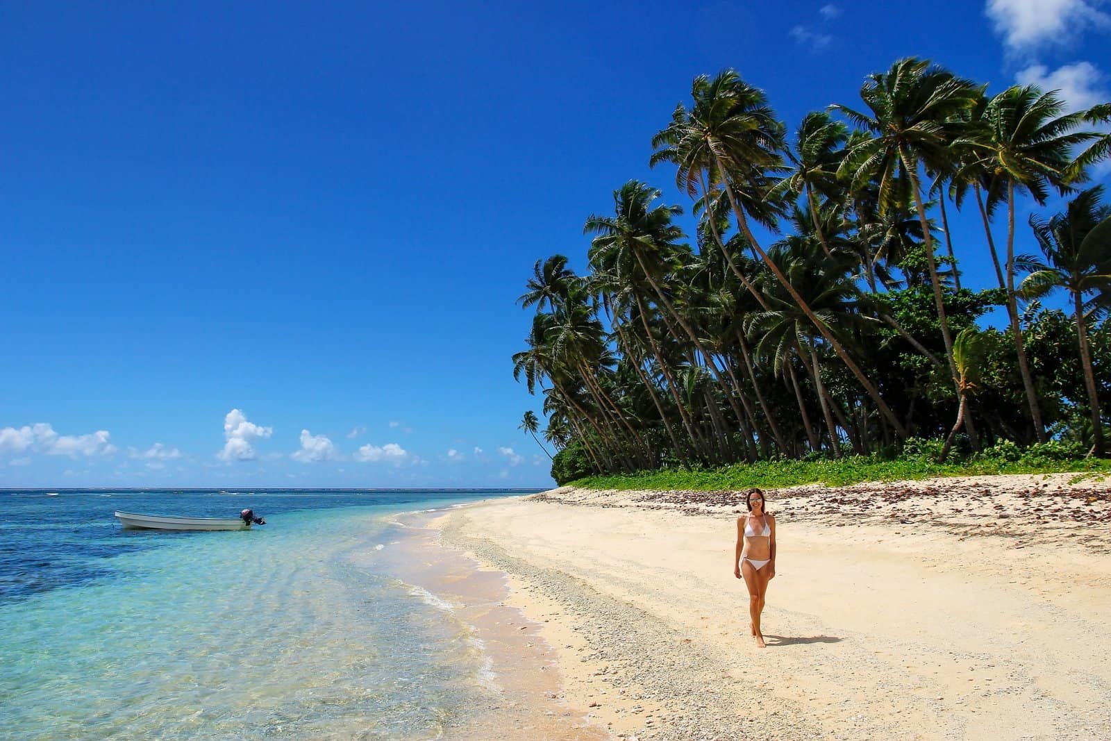 Young woman in bikini walking on a beach in lavena village on taveuni island, fiji.