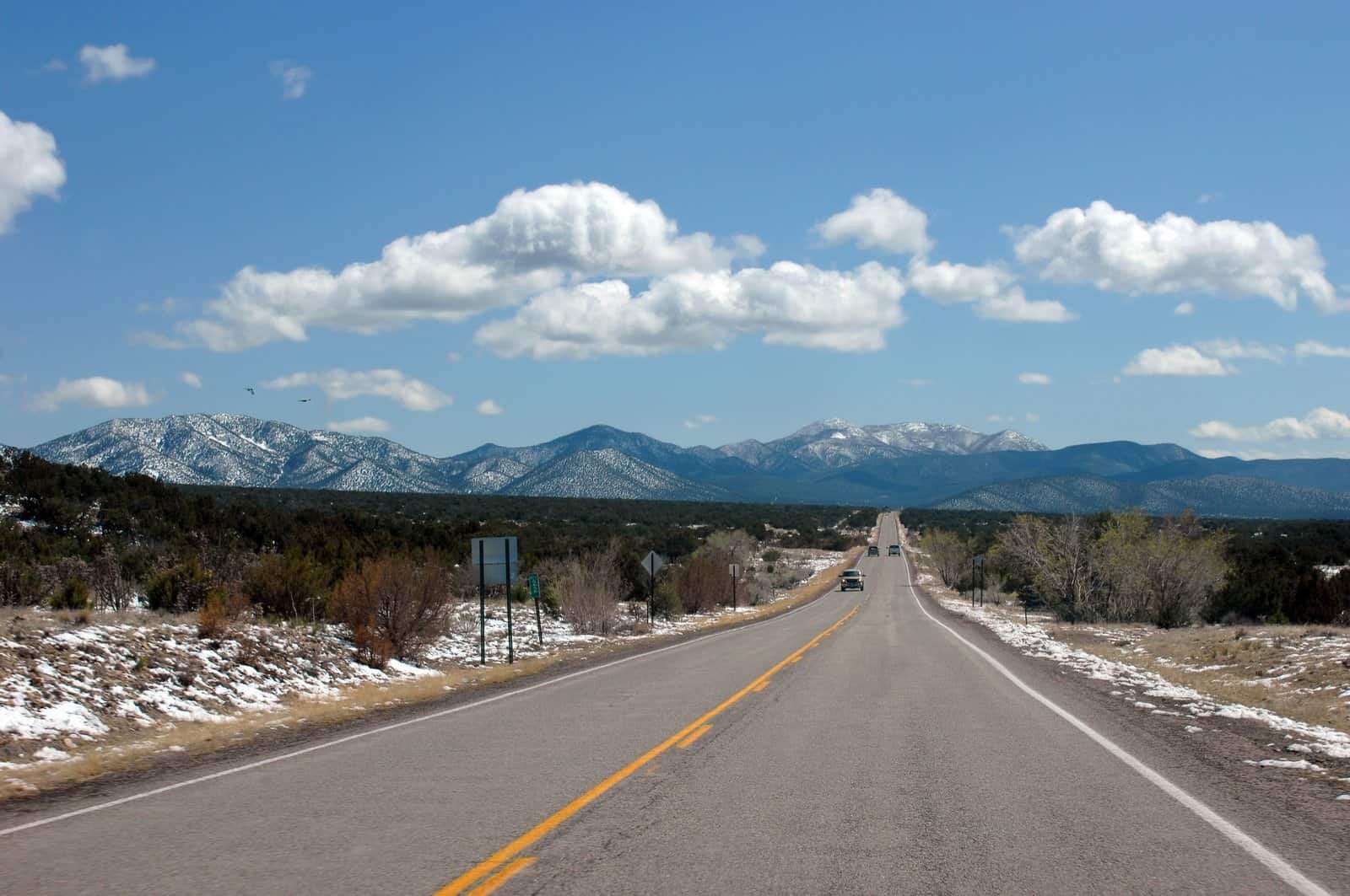 Snow capped mountains loom just beyond the next hill.